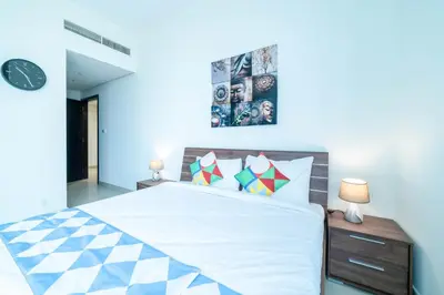 a bedroom with a bed and a clock on the wall at OYO 589 Najma Tower, Two bedrooms Apartments, Sports City in Dubai