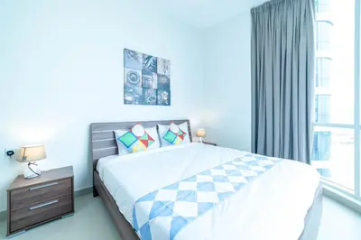 a bedroom with a large bed and a window at OYO 589 Najma Tower, Two bedrooms Apartments, Sports City in Dubai
