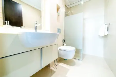 a white bathroom with a sink and a toilet at OYO 589 Najma Tower, Two bedrooms Apartments, Sports City in Dubai
