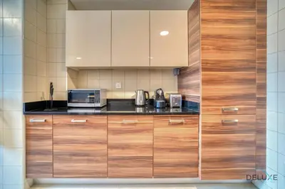a kitchen with wooden cabinets and a microwave at Rustic 2BR at Sparkle Tower 1 Dubai Marina by Deluxe Holiday Homes in Dubai