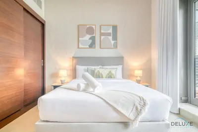 a bedroom with a large white bed with two lamps at Rustic 2BR at Sparkle Tower 1 Dubai Marina by Deluxe Holiday Homes in Dubai