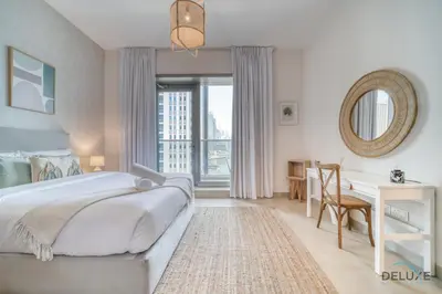 a bedroom with a bed and a desk and a window at Rustic 2BR at Sparkle Tower 1 Dubai Marina by Deluxe Holiday Homes in Dubai