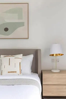 a bedroom with a bed and a table with a lamp at Frank Porter - Belgravia 3 in Dubai