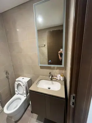 a bathroom with a toilet and a sink and a mirror at OYO 887 Home A1607 Sobha Creek Vistas - 1BR in Dubai