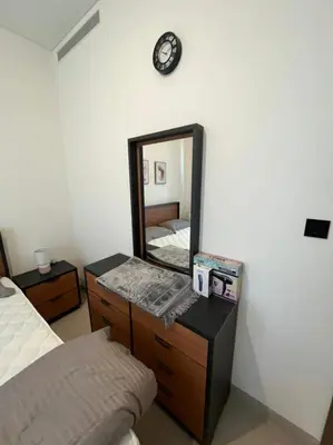 a bedroom with a mirror on the wall and a bed at OYO 887 Home A1607 Sobha Creek Vistas - 1BR in Dubai