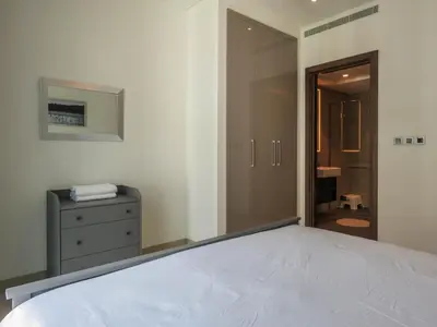 a bedroom with a bed and a door to a bathroom at OYO 755 Home Sobha Greens in Dubai