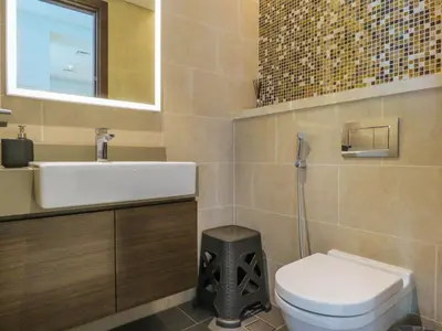 a bathroom with a sink and a toilet and a mirror at OYO 755 Home Sobha Greens in Dubai