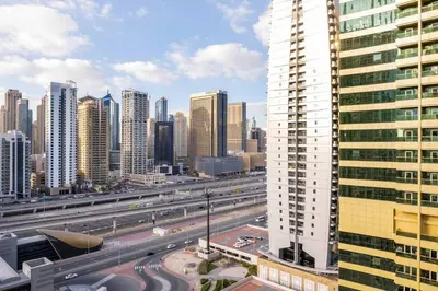 a view of a city with a highway and buildings at La Buena Vida Holiday Homes - Luxe 1BD, boutique apt full lakeview 1m to Metro, Lake & Almas Tower in Dubai