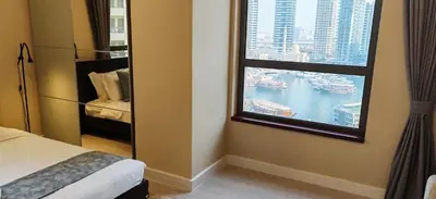 a bedroom with a window with a view of a harbor at La Buena Vida Holiday Homes, Luxe, 3BR with, full kitchen, Marina View, by JBR Beach, Tram & Marina in Dubai