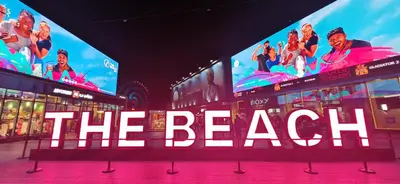 two large television screens with the beach on them at La Buena Vida Holiday Homes, Luxe, 3BR with, full kitchen, Marina View, by JBR Beach, Tram & Marina in Dubai