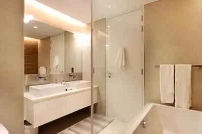 a white bathroom with a sink and a shower at Livbnb - Upgraded 2BR, Near Shopping & Dining Hubs in Dubai
