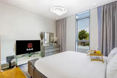 a hotel room with a large bed and a tv at Livbnb - Upgraded 2BR, Near Shopping & Dining Hubs in Dubai