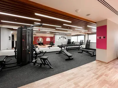 a gym with treadmills and chairs in a room at Trophy - Sky High Haven Suite in Dubai