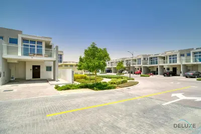 a parking lot in front of a apartment complex at Cheerful 3BR Townhouse at DAMAC Hills 2, Dubailand by Deluxe Holiday Homes in Dubai