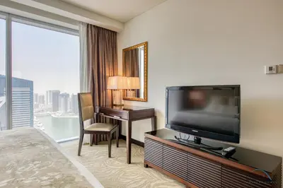 a hotel room with a flat screen tv and a desk at Lush 1 BR at The Address Residences Dubai Marina by Deluxe Holiday Homes in Dubai