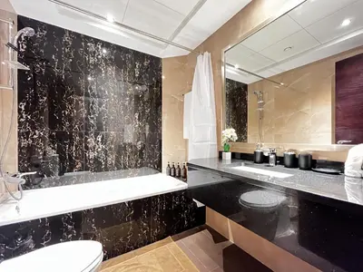 a bathroom with a toilet and a sink and a mirror at Trophy Stays - Supreme Sunrise Suites w Burj Khalifa view - Studio in Dubai