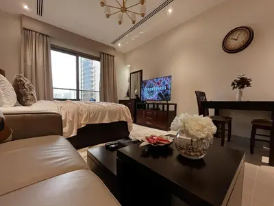 a large living room with a couch and a table at Trophy Stays - Supreme Sunrise Suites w Burj Khalifa view - Studio in Dubai