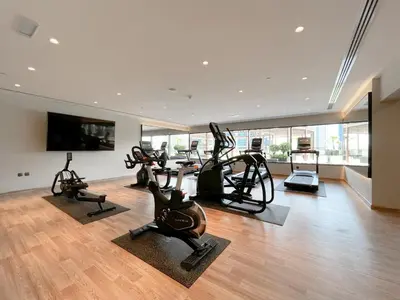 a gym with treadmills and exercise bikes in a room at Trophy Stays - Supreme Sunrise Suites w Burj Khalifa view - Studio in Dubai