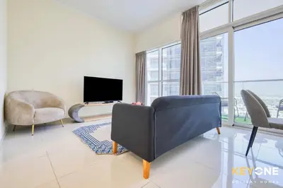 a living room with a couch and a tv at Carson Elegant Living in One Bedroom in Dubai