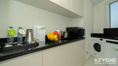 a kitchen with a counter with a washing machine at Carson Elegant Living in One Bedroom in Dubai
