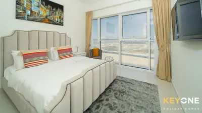 a bedroom with a large bed with a large window at Carson Elegant Living in One Bedroom in Dubai