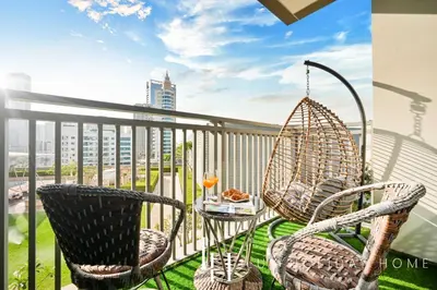 a balcony with two chairs and a table and a swing at LUX 52 42 Deluxe Marina view suite 1 in Dubai
