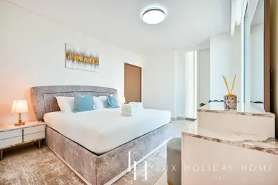 a bedroom with a large bed with blue pillows at LUX 52 42 Deluxe Marina view suite 1 in Dubai