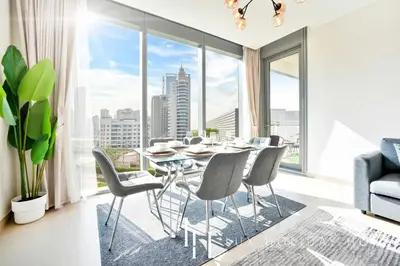 a dining room with a table and chairs and a large window at LUX 52 42 Deluxe Marina view suite 1 in Dubai