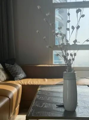 a vase with flowers on a table in a living room at Unique 3BR DUPLEX Apartment with Marina Views in Dubai