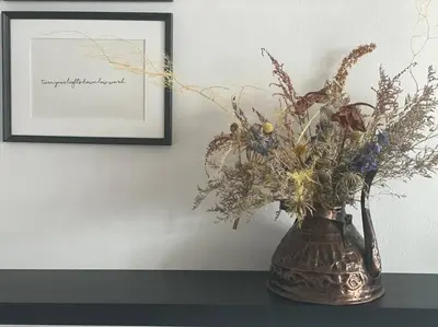 a vase filled with dried flowers on a table at Unique 3BR DUPLEX Apartment with Marina Views in Dubai