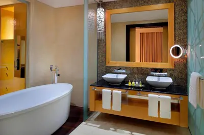 a bathroom with two sinks and a tub and a mirror at Marriott Hotel Al Jaddaf, Dubai in Dubai