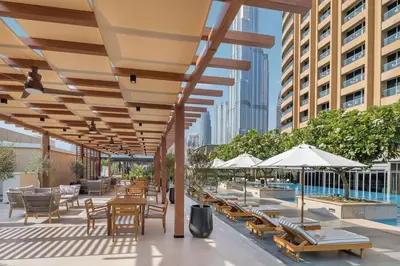 an outdoor patio with tables and chairs and umbrellas at FAHH - Superior 1BHK Address Dubai Mall Residences in Dubai