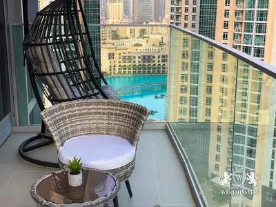 a rocking chair on a balcony with a view of a city at Westminster Opera Burj Khalifa in Dubai