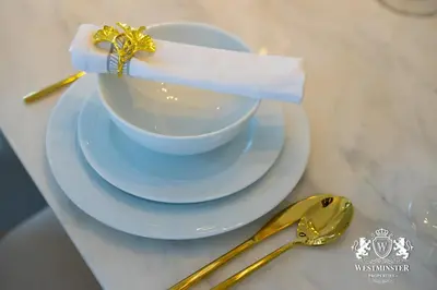 a white cup and saucers with a napkin on top at Westminster Opera Burj Khalifa in Dubai