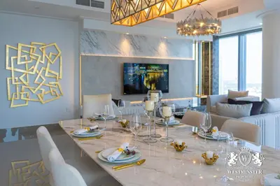 a dining room and living room with a table and chairs at Westminster Opera Burj Khalifa in Dubai