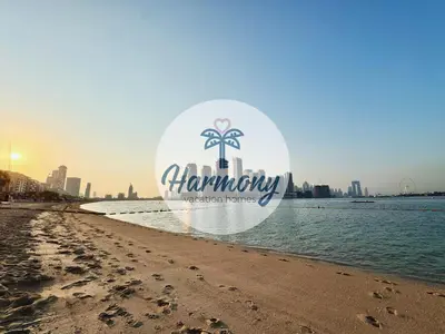 a sign on the beach with the city in the background at Harmony Vacation Homes - North Residence in Dubai
