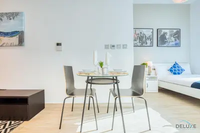 a room with a table and two chairs and a bed at Airy Studio in Studio One Dubai Marina by Deluxe Holiday Homes in Dubai