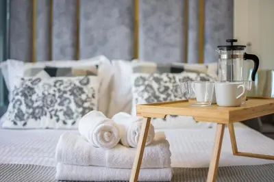 a table with towels and a coffee maker on a bed at Brand new 1 bedroom apartment Dubai Hills 601 in Dubai
