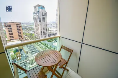 a balcony with two chairs and a table and a view at Luxury Escapes - Furnished studio with balcony in Royal Oceanic in Dubai