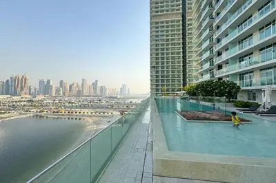 a person standing in a swimming pool on a building at Tropical Home w Private Beach in Emaar Beachfront in Dubai