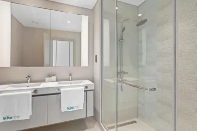 a bathroom with a glass shower and a sink at Tropical Home w Private Beach in Emaar Beachfront in Dubai