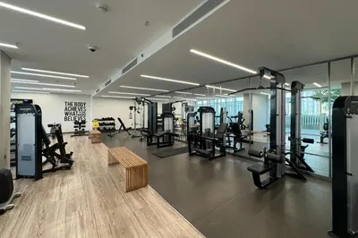 a gym with several treadmills and benches in a room at Tropical Home w Private Beach in Emaar Beachfront in Dubai