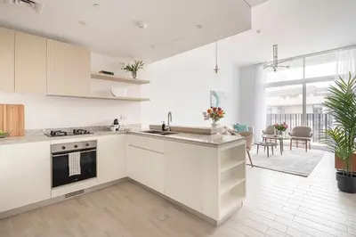 a white kitchen with a sink and a stove at Frank Porter - Belgravia 3 in Dubai