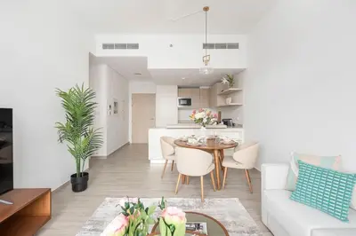 a living room with a table and a kitchen at Frank Porter - Belgravia 3 in Dubai