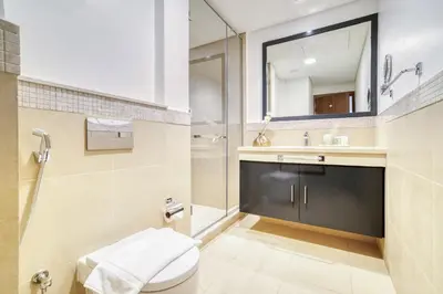 a bathroom with a toilet and a sink and a mirror at Burj Vista, Downtown Dubai - Burj Khalifa View - Mint Stay in Dubai