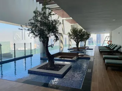 a pool with a tree in the middle of a building at Paramount Midtown - Fantastic 2 Bedroom Apartment with Sea View in Dubai