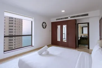 a bedroom with a large white bed and a large window at Spacious 2 BR with Amazing Marina View Rimal JBR in Dubai