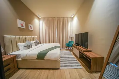 a bedroom with a bed and a flat screen tv at Big Modern Studio in Park View JVC in Dubai