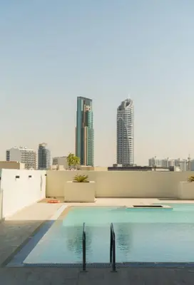 a swimming pool on top of a building with a city skyline at Big Modern Studio in Park View JVC in Dubai