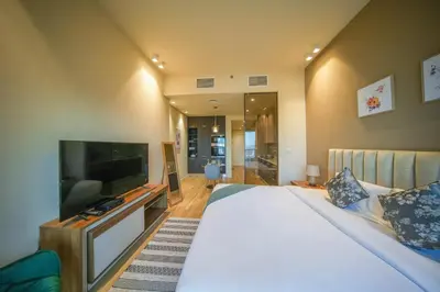 a bedroom with a large bed and a flat screen tv at Big Modern Studio in Park View JVC in Dubai